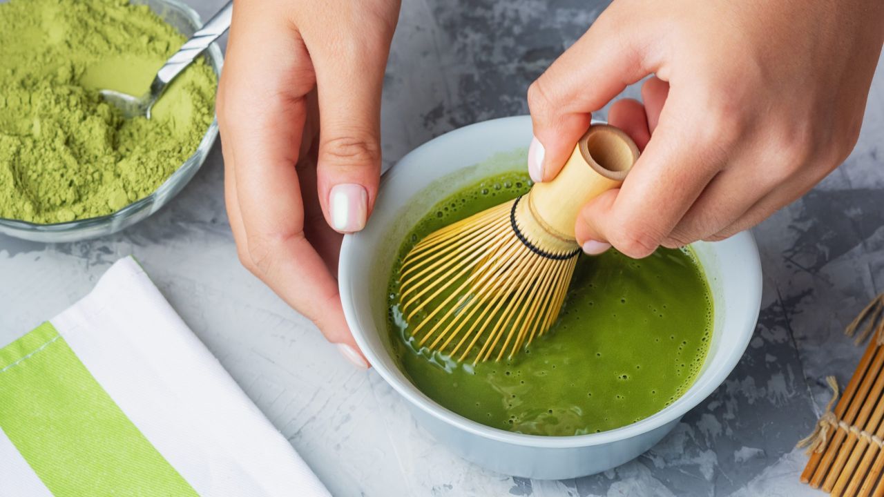 girl stirs matcha green tea bamboo whisk process making tea close up scaled 01d36cbc