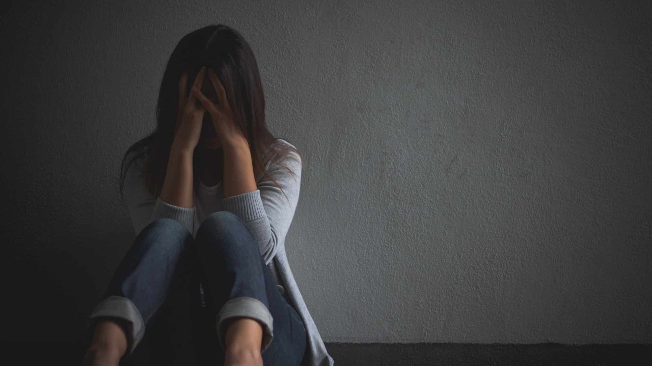mulher triste abracar seu joelho e chorar sentado sozinho em um quarto vazio 1 scaled 8d3609b6