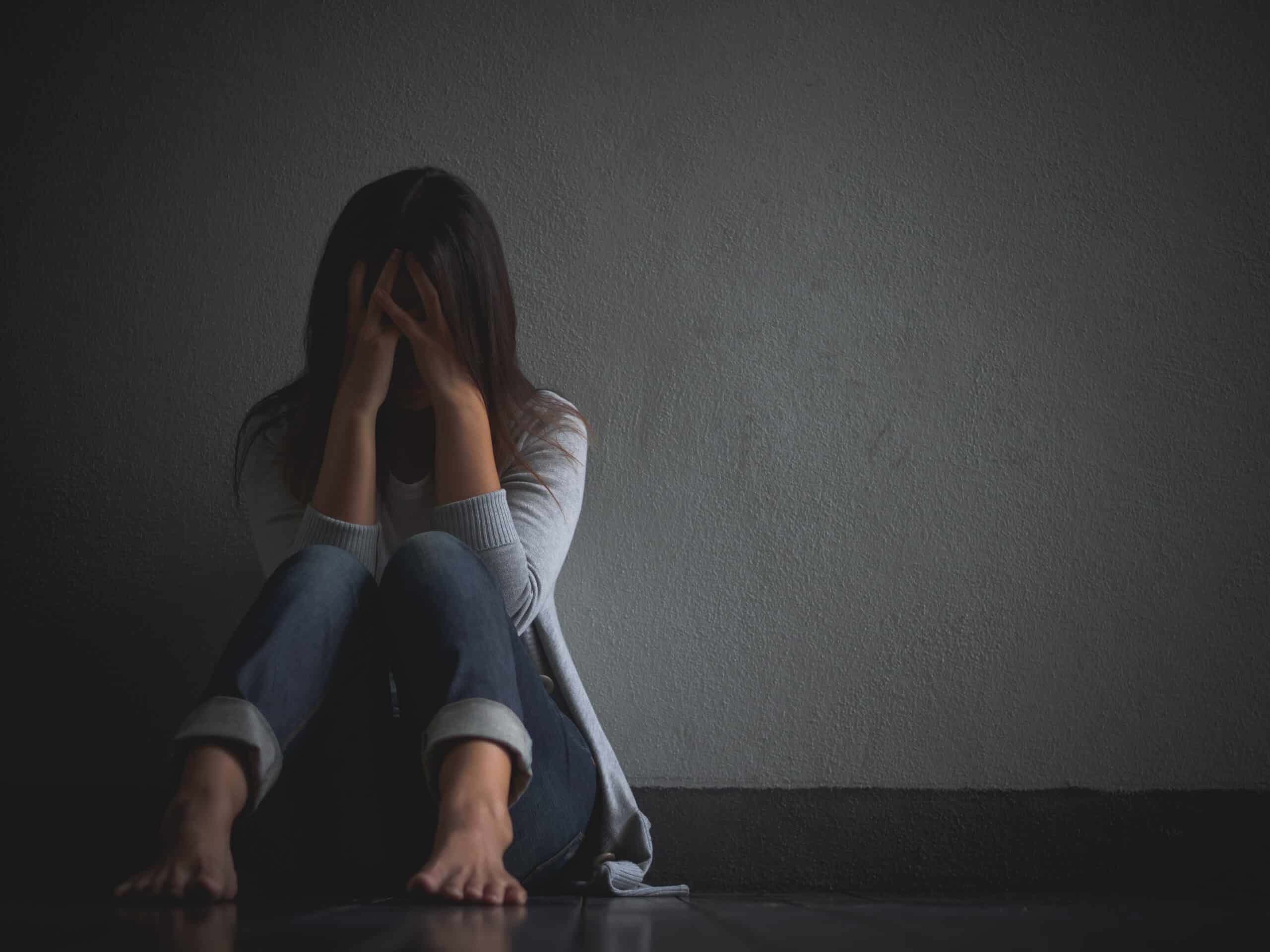 mulher triste abracar seu joelho e chorar sentado sozinho em um quarto vazio 1 scaled 97bfa995