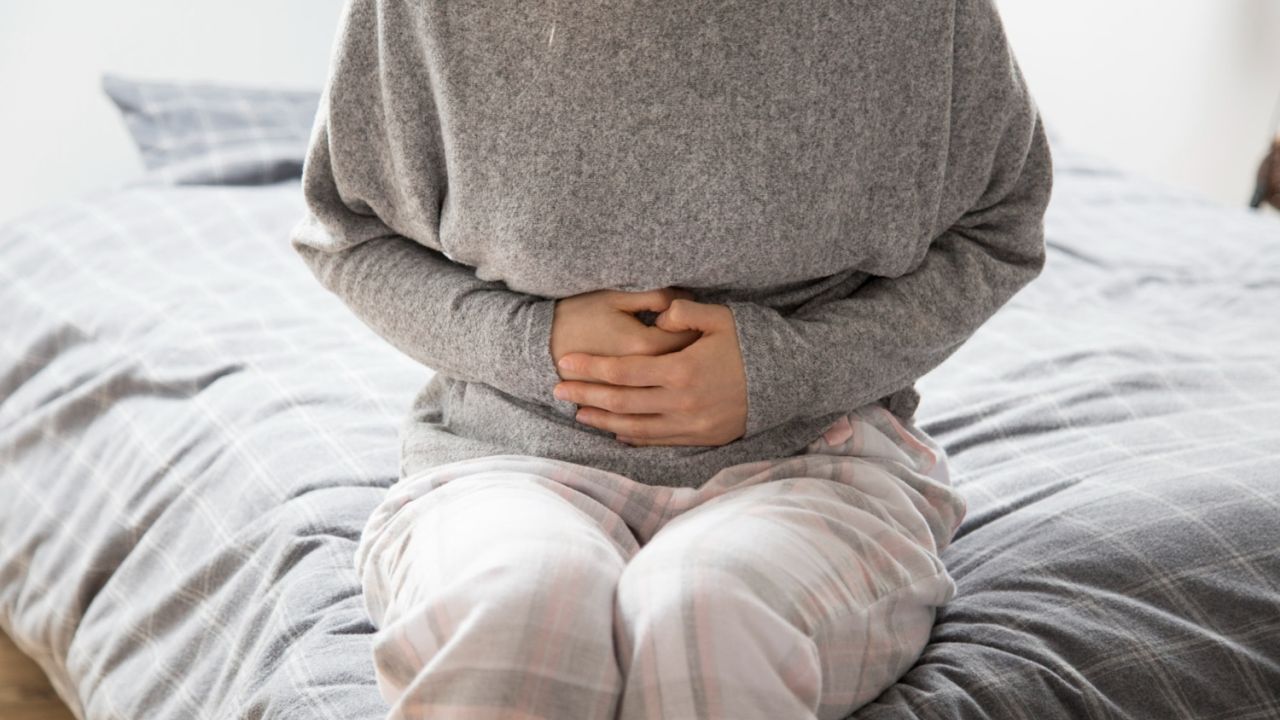 sick woman with hands stomach suffering from intense pain a3a3d860