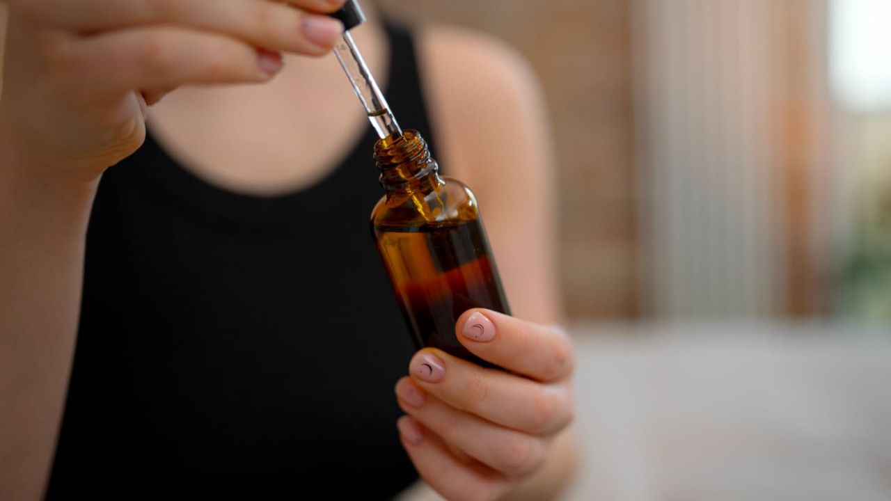 front view woman holding serum bottle c73fb7ee