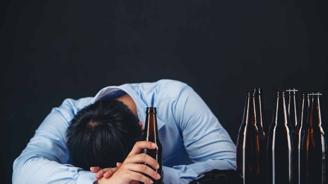 alcoholic asian man with lot beer bottles scaled db899388