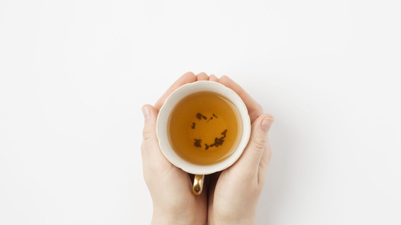 hand holding tea scaled f0403577