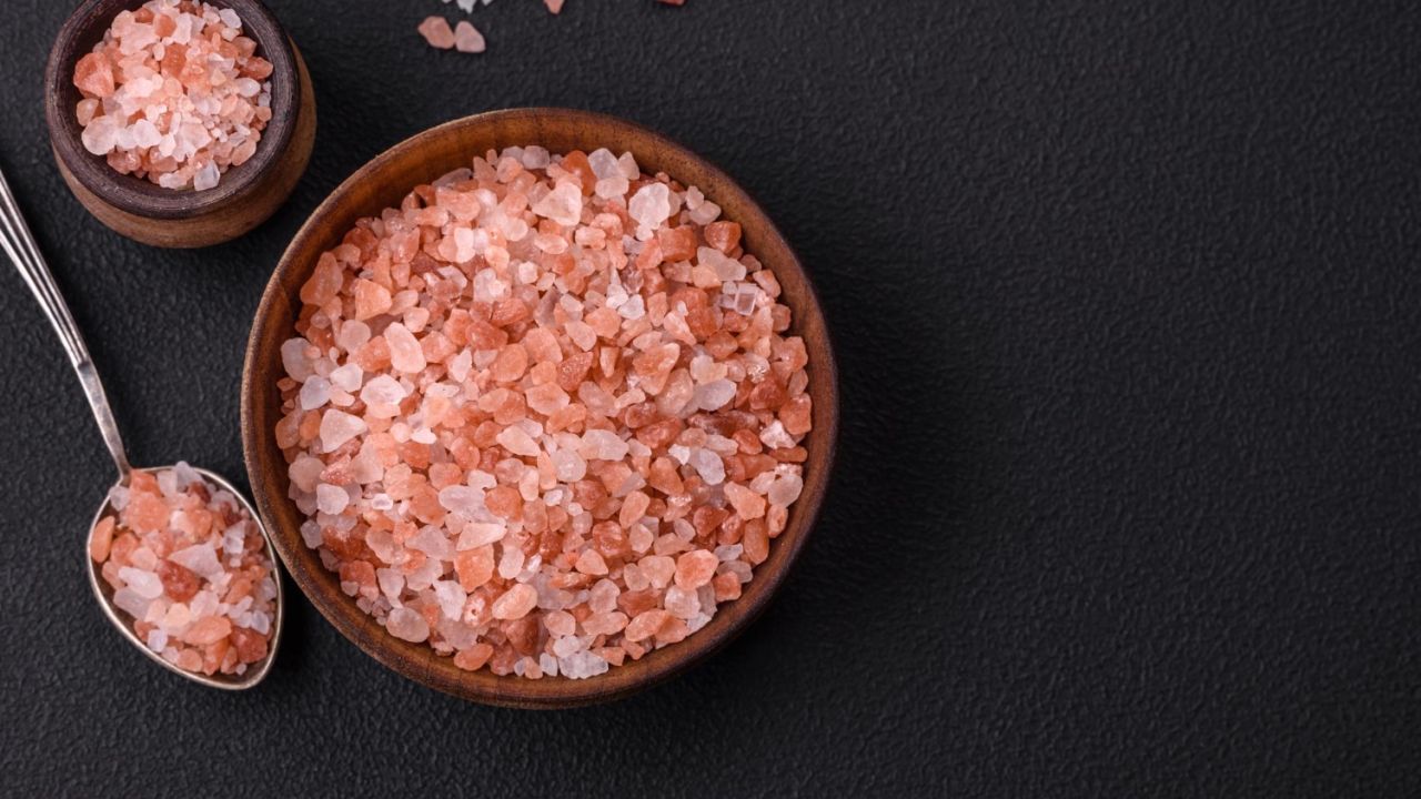 pink himalayan salt wooden bowl dark concrete background seasonings additives kitchen f97f8d13