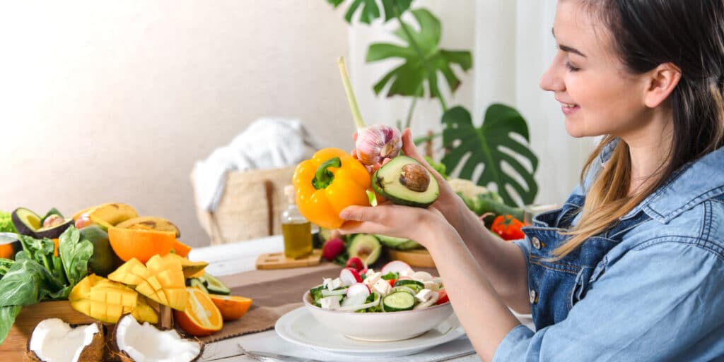 young happy woman eating salad table